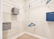 Thumbnail 7 of 31 - A walk-in closet with a blue box on the shelf.