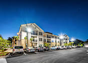 Thumbnail 33 of 45 - A parking lot with cars parked in front of a building.