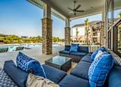 Thumbnail 17 of 45 - A patio with a sofa and pillows is shown.