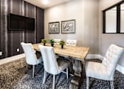 Thumbnail 7 of 53 - A dining room with a wooden table and white chairs.