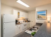 Thumbnail 12 of 28 - A kitchen with white cabinets and a fridge.