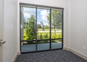 Thumbnail 49 of 54 - A room with a glass door leading to a green outdoor area.