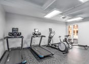 Thumbnail 23 of 33 - A gym with treadmills, exercise bikes, and elliptical machines.