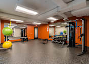 Thumbnail 19 of 33 - A gym with orange walls and a variety of equipment.