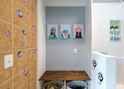 Thumbnail 13 of 28 - A bathroom with a brown tiled wall and a white cabinet.