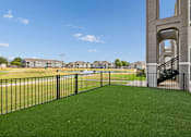 Thumbnail 25 of 39 - A black fence surrounds a green lawn in front of a building.