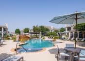 Thumbnail 19 of 23 - a swimming pool with patio furniture and umbrellas in front of a resort style at Orion Prosper Lakes, Prosper, TX, 75078