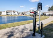 Thumbnail 24 of 33 - a sign for a bike path next to a body of water  at Orion Prosper, Prosper