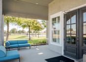 Thumbnail 16 of 33 - a patio with blue couches and chairs and a door at Orion Prosper, Prosper, TX, 75078