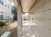 Thumbnail 14 of 33 - a walkway leading to a building with a fence and a bench at Orion Prosper, Prosper, TX, 75078