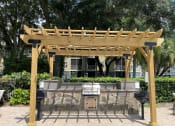 Thumbnail 6 of 31 - a pergola with a grill in front of a building