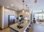 Thumbnail 3 of 46 - A modern kitchen with a large island and stainless steel appliances.