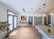 Thumbnail 2 of 46 - A kitchen with a long counter and bar stools.