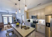Thumbnail 1 of 46 - A modern kitchen with a large island and stainless steel appliances.