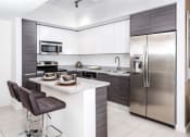 Thumbnail 9 of 14 - a kitchen with white cabinets and stainless steel appliances at Regatta at New River, Fort Lauderdale Florida