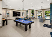 Thumbnail 3 of 33 - A billiard table is in the middle of a room with a pool table and a bar.