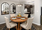 Thumbnail 14 of 33 - A dining room with a round wooden table and chairs.
