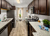 Thumbnail 8 of 33 - A kitchen with dark wood cabinets and a granite countertop.