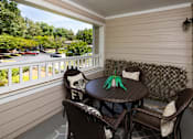 Thumbnail 21 of 33 - A patio with a table and chairs overlooking a parking lot.