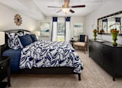 Thumbnail 19 of 33 - A bedroom with a large bed and a ceiling fan.