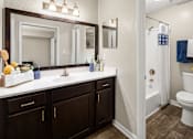 Thumbnail 18 of 33 - A bathroom with a white toilet and a white sink.