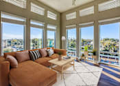 Thumbnail 11 of 34 - A living room with a brown couch and a white rug.