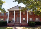 Thumbnail 2 of 16 - a red brick house with three white pillars in front of it