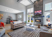 Thumbnail 1 of 31 - A living room with a fireplace and a television on the wall.