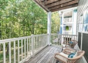 Thumbnail 10 of 38 - a porch with two wicker chairs and a view of trees