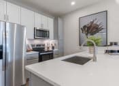 Thumbnail 13 of 43 - Madison, AL, Luxury Apartments - Paxton Place - Kitchen with Quartz Countertops, Stainless Steel Appliances, and Two-Toned Cabinetry.