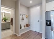 Thumbnail 25 of 43 - a hallway with a refrigerator and a door to a kitchen