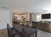 Thumbnail 15 of 43 - A modern dining room with a dark table and chairs.