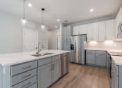 Thumbnail 12 of 43 - a kitchen with white cabinets and a stainless steel refrigerator