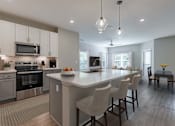 Thumbnail 11 of 43 - A modern kitchen with a large island and bar stools.
