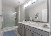Thumbnail 27 of 43 - A bathroom with a toilet, sink, and mirror.