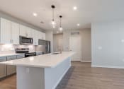 Thumbnail 14 of 43 - an empty kitchen with a large white counter top