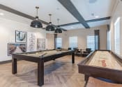 Thumbnail 32 of 43 - Luxury Apartments in Madison, AL, for Rent - Paxton Place - Game Room with Shuffle Board, Pool Table, Coffee Tables, and Lounge Chairs.