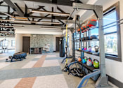 Thumbnail 37 of 43 - A gym with a variety of equipment including a pull up bar.