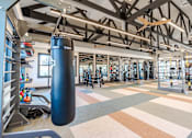 Thumbnail 40 of 43 - A gym with a punching bag hanging from the ceiling.