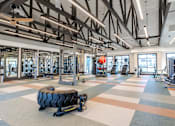 Thumbnail 38 of 43 - A gym with a variety of equipment and a tire on the floor.