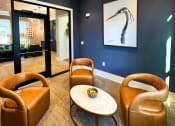 Thumbnail 13 of 29 - a living room with blue walls and leather chairs and a table