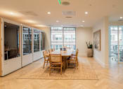 Thumbnail 8 of 36 - A dining room with a table and chairs.