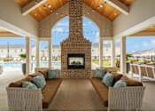 Thumbnail 51 of 65 - A modern living room with a fireplace and a view of the pool and buildings outside.