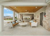 Thumbnail 54 of 65 - A patio with a white table and chairs and a brick wall.