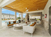 Thumbnail 55 of 65 - A patio with a white wicker sofa and a table with a fan.