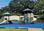 Thumbnail 21 of 23 - A playground with a slide, swings, and a wooden structure.