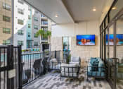 Thumbnail 37 of 48 - a living room with a couch and chairs on a balcony