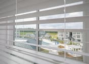 Thumbnail 35 of 54 - a view from a window of a building with white blinds