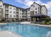 Thumbnail 51 of 56 - a swimming pool in front of an apartment building