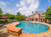 Thumbnail 48 of 69 - a swimming pool with a house in the background